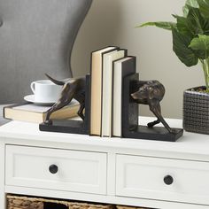 a dog figurine sitting on top of a book shelf next to some books