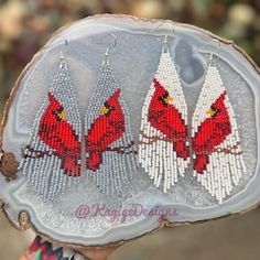 a person holding up a piece of wood with red birds on it