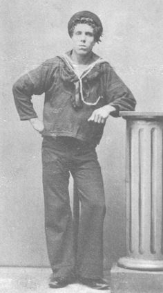 an old black and white photo of a man standing next to a trash can with his hands on his hips