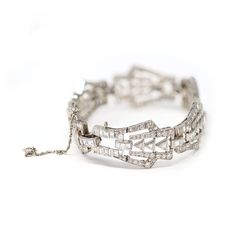 Art Deco platinum and diamond bracelet, designed as a series of openwork geometric links set throughout with various-cut diamonds weighing approximately 9 carats, GH color VS clarity. The gross weight is 37.2 grams, length 7 ⅛ inches, width ¾ inch. Art Deco Platinum Diamond Cut Bracelet, Art Deco Diamond Cut Platinum Bracelet, Art Deco Silver Diamond Bracelet With Brilliant Cut, Silver Art Deco Diamond Bracelet With Brilliant Cut, Silver Brilliant Cut Diamond Bracelet In Art Deco Style, Diamond White Platinum Bracelet With Baguette Diamonds, Platinum Diamond Bracelet With Baguette Diamonds In Diamond White, Art Deco Platinum Silver Tennis Bracelet, Art Deco Silver Diamond Cut Bracelet