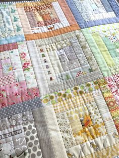 a close up of a patchwork quilt with many different colors and designs on it