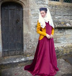 Ladies would often dress up there kirtle by wearing and surcoat over the top which could be styled simply or made lavishly with fur trims and fancy fabric. We offer a simple style surcoat with a low hanging side openings which is made from your chosen coloured duchess poly Velvet fabric colours in the pictures . The inside is lined in a cream cotton fabric for comfort and structure.  We will need your hip size and shoulder to shoulder measurements as well as you shoulder to floor measurements ( Regency Style Long Sleeve Medieval Costume Dress, Winter Medieval Dress For Larp With Historical Design, Vintage Medieval Dress For Cosplay And Festivals, Regency Style Long Sleeve Medieval Dress For Festivals, Regency Style Medieval Costume Dress With Historical Design, Winter Medieval Dress With Historical Design, Historical Costume For Medieval Festivals With Historical Design, Regency Style Medieval Dress For Larp, Vintage Medieval Dress For Larp With Historical Design