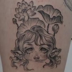 a woman's face with flowers and leaves on her back tattoo by artist unknown