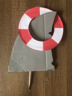 a piece of cardboard with a life preserver on it sitting on top of a wooden table