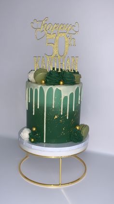 a green and gold birthday cake with white frosting on it's bottom tier