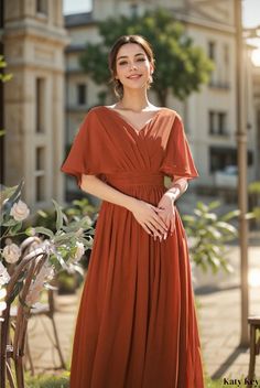 a woman in an orange dress posing for the camera with her hands on her hips