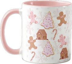 a pink and white coffee mug with gingerbread cookies on the inside, along with other gingerbread decorations