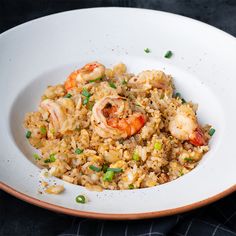 rice with shrimp and scallops in a white bowl on a black tablecloth