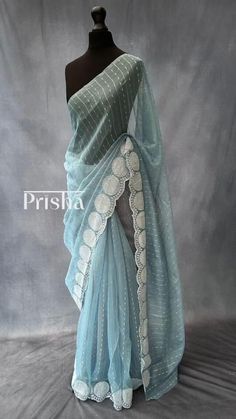 Powder blue jute organza saree with scallop borders. The saree is complimented with off-white embroidery and sequins work. Blouse: off-white semi dupion silk [Unstitched]. Please note there may be slight colour variations due to lighting. please send us a message if you want blouse material separated  and need pico ( no extra charge) Elegant Light Blue Saree With Zari Work, Elegant Light Blue Saree With Cutdana, Elegant Light Blue Saree With Dupatta, Elegant Blue Saree With Chikankari Embroidery, Elegant Light Blue Saree With Resham Embroidery, Elegant Light Blue Saree For Festivals, Light Blue Chanderi Saree For Wedding, Elegant Saree With Border For Celebrations, White Saree With Border For Wedding