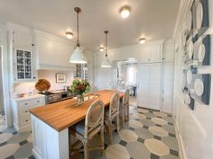 a kitchen with white cabinets and black and white checkered flooring on the walls