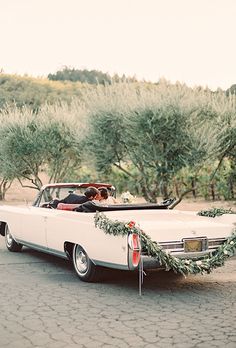 an old car is decorated with wreaths and garland