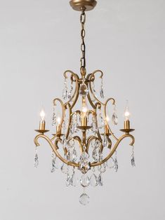 a gold chandelier with crystal drops hanging from it