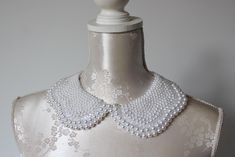 Handmade collar necklace with white and clear pearls in different sizes.  Peter pan collar style. Ribbon tied on the back. Adjustable to every neck size. Every single bead is handsewn.  Collar gives a chic touch to simple dresses and blouses.  One size. Handmade item. Wonderful gift for women or female friends. Please check out other items in my shop. You can find there collars in different shapes, colors and materials. Great to wear everyday and also for special occasions. Necklace With Pearls, Single Bead, Beaded Collar, Bib Necklaces, Female Friends, Pan Collar, Peter Pan Collar, White Collar, Collar Necklace