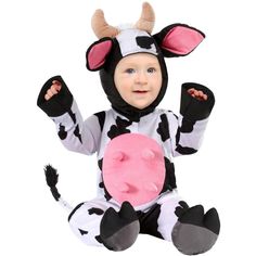 a baby dressed in a cow costume sitting on the ground with his hands up and holding a doughnut