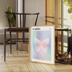 a framed poster sitting on top of a wooden floor next to a chair and table