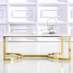 a white and gold coffee table in front of a wall