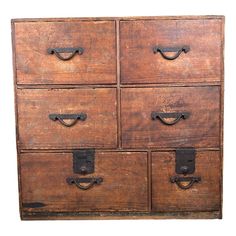 an old wooden dresser with four drawers and two handles on each drawer, which is open to reveal the contents