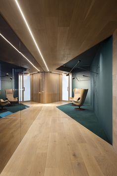 an empty room with chairs and mirrors on the walls is lit by recessed lights