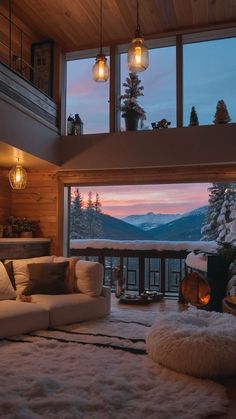 a living room filled with furniture and a large window overlooking the snow covered mountain range