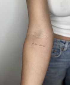 a woman's arm with a small tattoo that says love on the left side