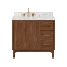 a bathroom vanity with marble top and two brass faucets on the sink side