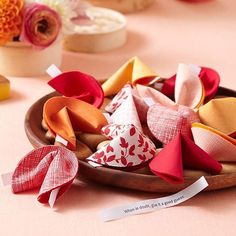 several different types of fabric bows on a wooden plate with flowers in the back ground