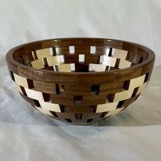 a wooden bowl with geometric designs on the sides and in the middle, sitting on a white surface