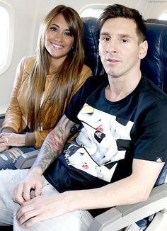 a man and woman sitting on an airplane