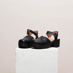 Dolores is a modern take on the classic Mary Jane clog. Here in a black soft leather with black wood-effect sole, this gorgeous clog will see you through the season in style. Handcrafted from premium leather, the Dolores clog features a rounded toe, block heel and adjustable ankle straps. With its cushioned, flexible sole, and padded anatomical footbed, Dolores is both chic and supremely comfortable. Heel 5.5 cm / 2.16 in Soft, flexible lightweight sole If you´re in between sizes, size down Modern Black Clogs With Rubber Heel Cap, Modern Clogs With Rubber Sole And Open Heel, Modern Open Heel Clogs With Rubber Sole, Black Low Heel Clogs, Modern Clogs With Wooden Open Heel, Modern Open Heel Clogs With Wooden Heel, Leather Clogs With Block Heel And Rubber Sole, Modern Clogs With Rubber Heel Cap And Round Toe, Modern Closed Toe Clogs With Stacked Heel