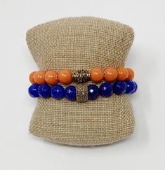 University of Florida Beaded Bracelets Show your school spirit with these Blue (Jade) and Orange (Jade) Gemstone Stretch Bracelets with Gold Plated Accent Bead. One size fits most. Stretches slightly for a comfortable fit. 10mm Beads Handmade in Jacksonville, Florida Each of our designs are hand crafted and may vary slightly. Casual Blue Jewelry For Game Day, Colleges In Florida, Memory Wire Wrap Bracelets, Blue Jade, Jade Gemstone, Wire Wrapped Bracelet, Wrap Bracelets, Jacksonville Florida, University Of Florida