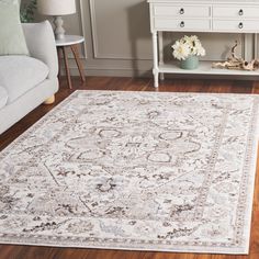 a living room area with a white couch, coffee table and rug on the floor