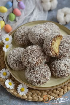 a plate filled with powdered donuts on top of a table next to flowers