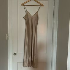 a tan dress hanging on a white door