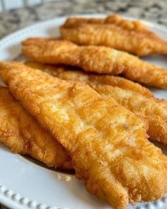 some fried fish sticks are on a white plate