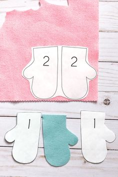 paper mitts cut out to look like the numbers two and three on top of each other