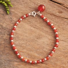 Gleaming with a natural magic orbs of red-orange carnelian alternate with shiny sterling silver beads as they circle the wrist. Peruvian artisan Adriana de Gadea creates this fascinating bracelet accented at the clasp with a carnelian charm that dangles. Red Carnelian Beaded Bracelets With Gemstone Beads, Red Carnelian Beaded Bracelet With Round Beads, Red Carnelian Beaded Bracelets With Round Beads, Red Carnelian Round Beads Bracelet, Red Carnelian Beaded Bracelets, Carnelian Round Beads Bracelet For Gift, Adjustable Carnelian Gemstone Beaded Bracelet, Carnelian Gemstone Beaded Bracelets, Carnelian Beaded Bracelets With Gemstones