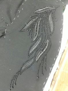 an embroidered piece of cloth with feathers on it