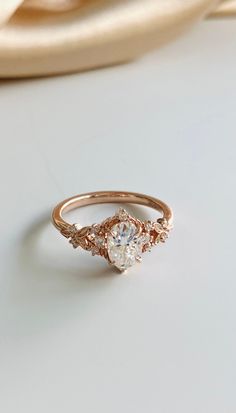 an engagement ring with two diamonds on top and one diamond in the middle, sitting on a white surface