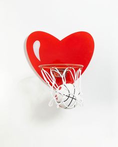 a basketball hoop with a red heart hanging from it's back end, on a white background