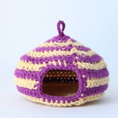 a purple and white crocheted cat house