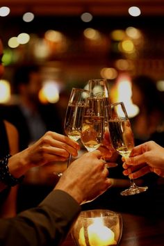 three people toasting with glasses of wine