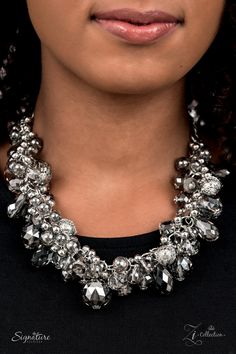 a woman wearing a black shirt and silver necklace with crystal stones on the collarline