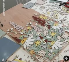 a person is working on an art project with wood and paper cut out to look like flowers