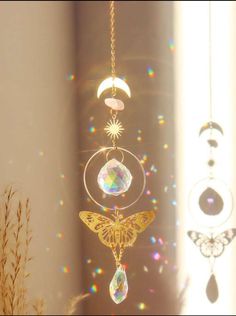 a wind chime hanging from the ceiling in front of a window with sun and moon