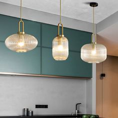 three lights hanging from the ceiling in a kitchen