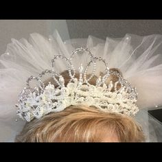 a close up of a person wearing a tiara with tulle and pearls on it