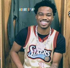 a young man sitting in front of a basketball jersey