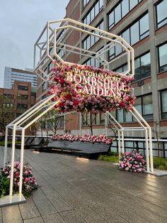 a large building with pink flowers on the front and side of it that says somerset gardens