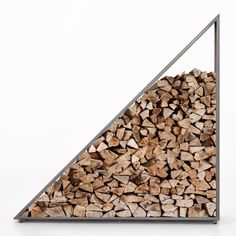 a pile of wood sitting in front of a metal frame on top of a white wall