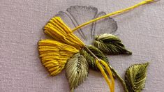 a close up of a piece of fabric with some flowers on it and two leaves